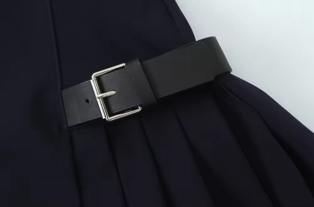 Robe noire avec jupe plissée et ceinture à la taille