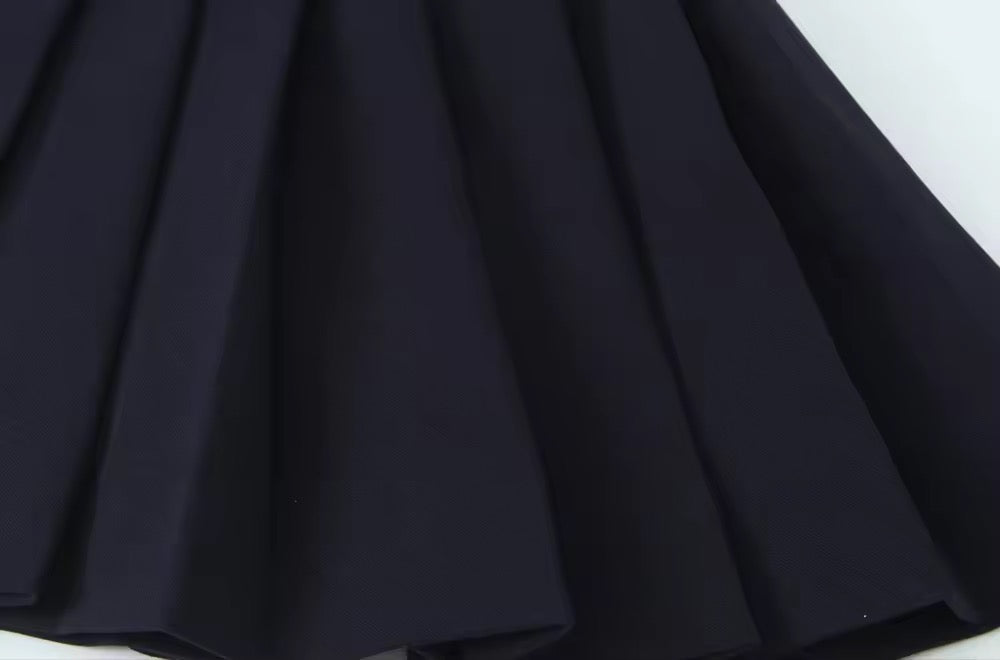 Robe noire avec jupe plissée et ceinture à la taille