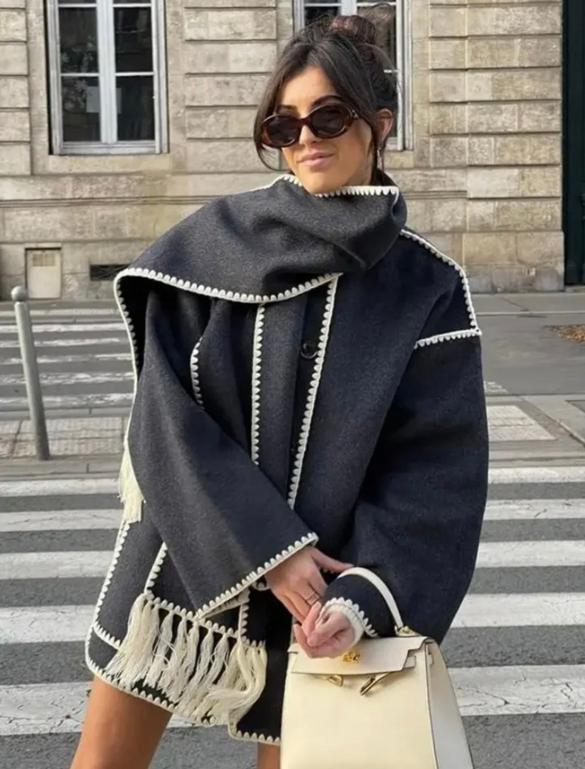 Elegant coat with black trim and fringe detail